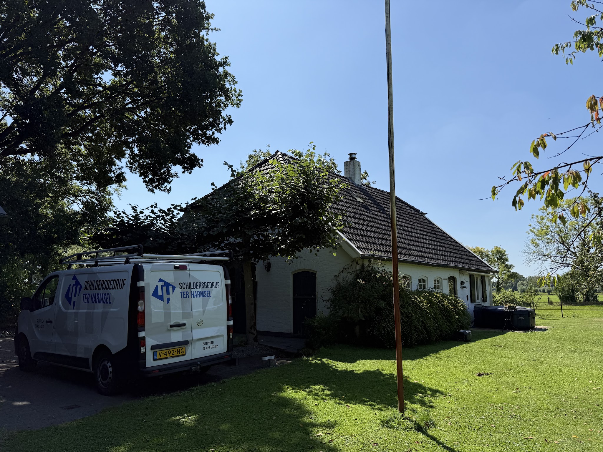 De bus van Schildersbedrijf ter Harmsel bij een boerderij in de zon